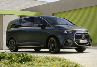 Mercedes-Benz VLE vor modernem Haus mit grünem Garagentor und gepflegtem Garten