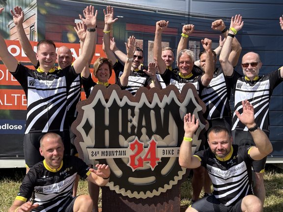 alle teilnehmenden Mitarbeiter von Schloz Wöllenstein stehen um eine Heavy 24 Statue