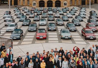 Große Gruppe von Menschen steht vor einer Vielzahl klassischer Mercedes-Benz Oldtimer auf dem chemnitzer Opernplatz zwischen historischen Gebäuden
